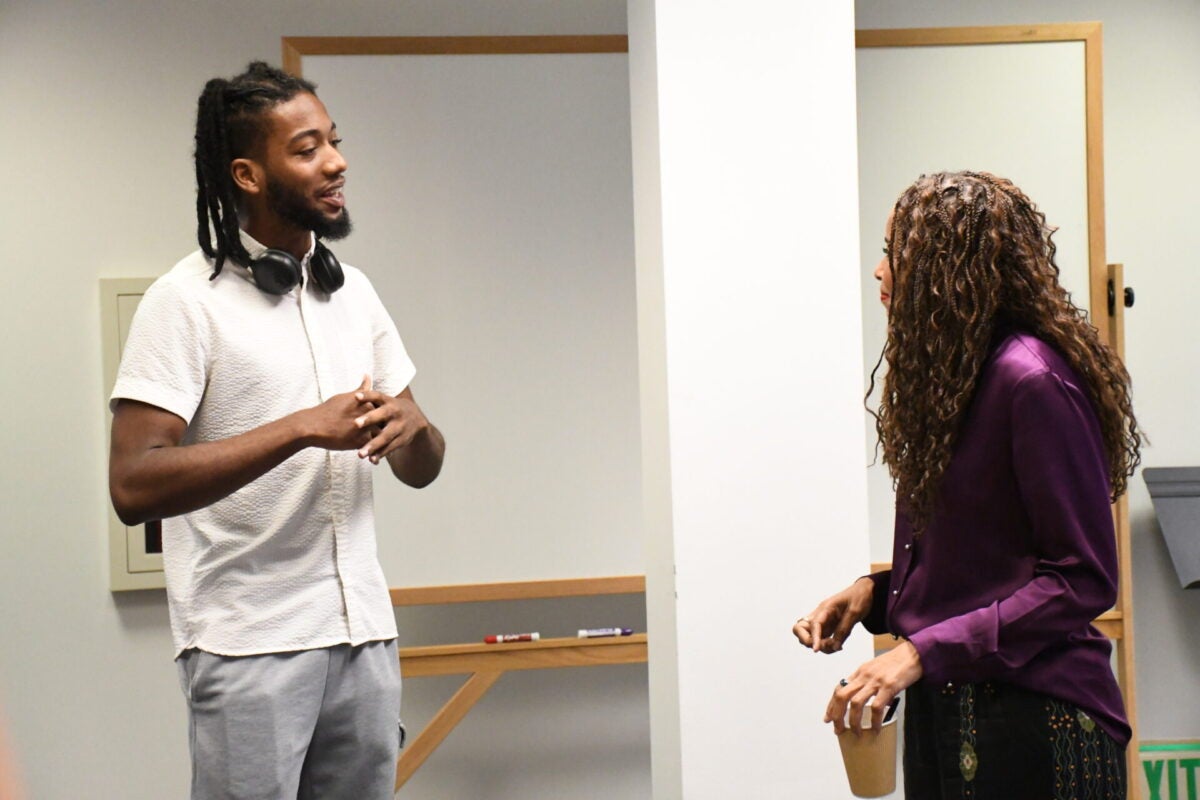 Two attendees in conversation at the book talk.