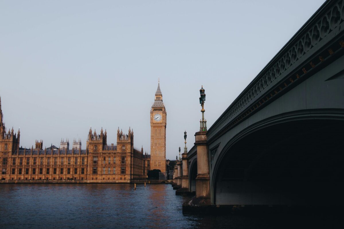 A landscape shot of London with the Big Ben clock tower centered on the horizon over a body of water